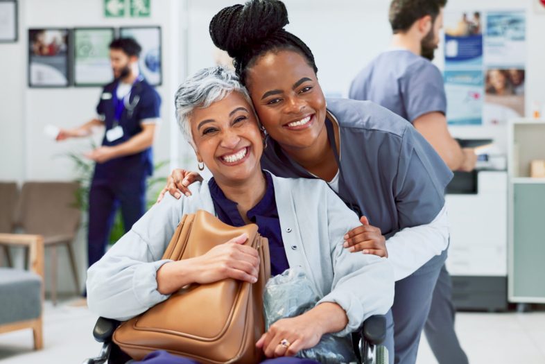Portrait, doctor and happy woman in wheelchair for recovery, healing or surgery success in hospital. Nurse, senior patient or smile in lobby for discharge, cancer free or rehabilitation in healthcare.