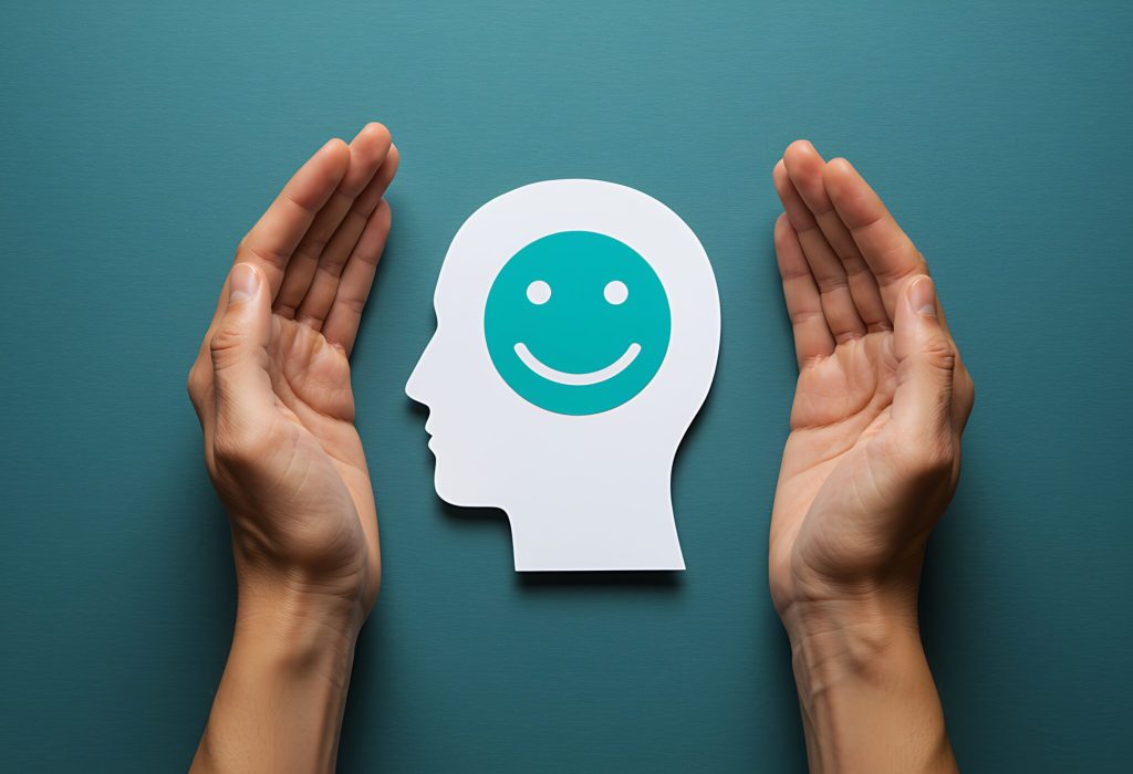 Protecting mental health concept showing hands shielding smiling face silhouette